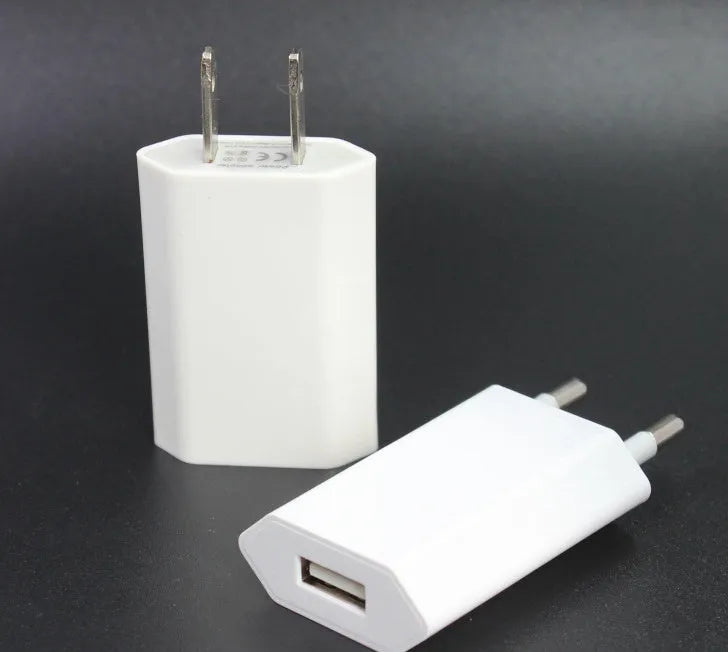 White 5V 2A USB travel charger and Lightning cable for iPhone and iPad on a wooden table.