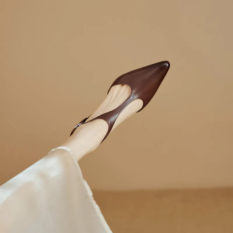 A pair of brown cowhide leather women's high heels with a pointed toe on a plain background.