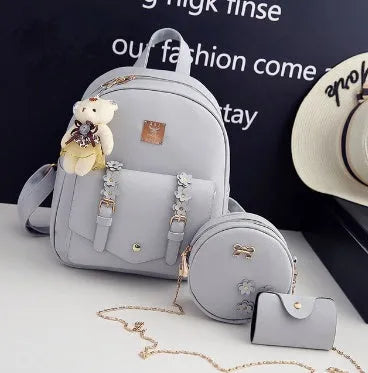 Women's three-piece leather backpack set with floral design including main backpack, shoulder bag, and card holder