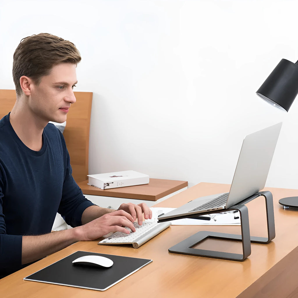Black aluminium alloy laptop stand on desk elevating computer for ergonomic use