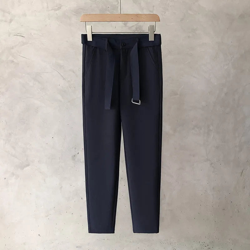 Boys slim straight-leg wool trousers in tapered cut, shown in black, on a hanger.