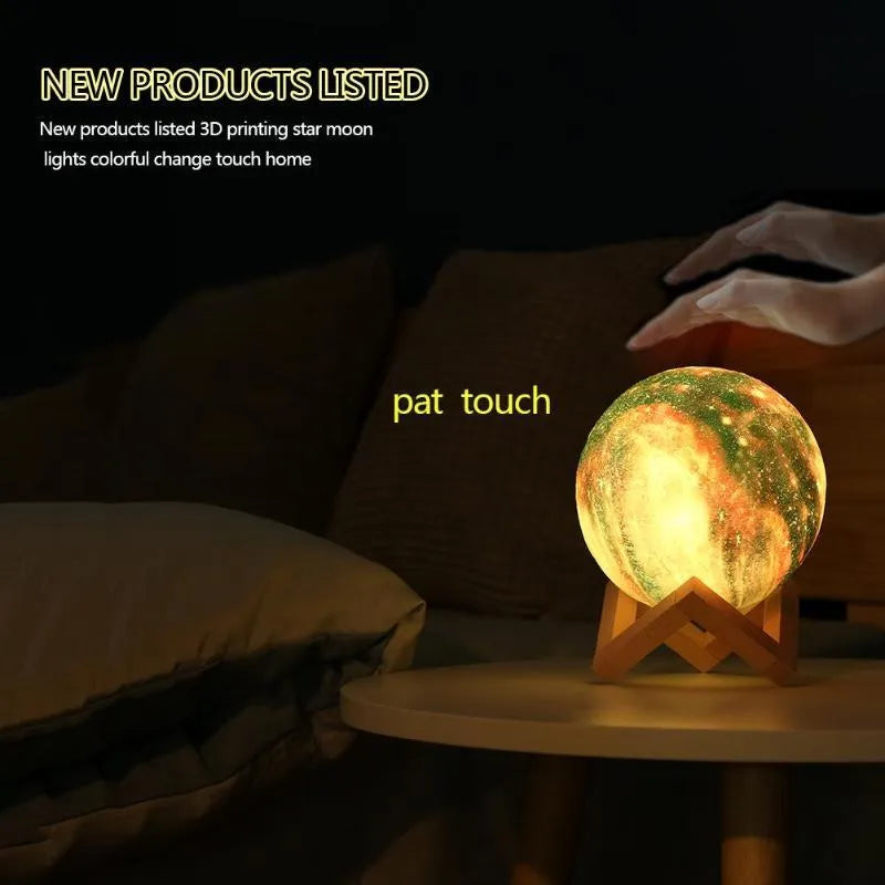White 3D-printed moon lamp on a table showing crater details, with a remote control beside it.