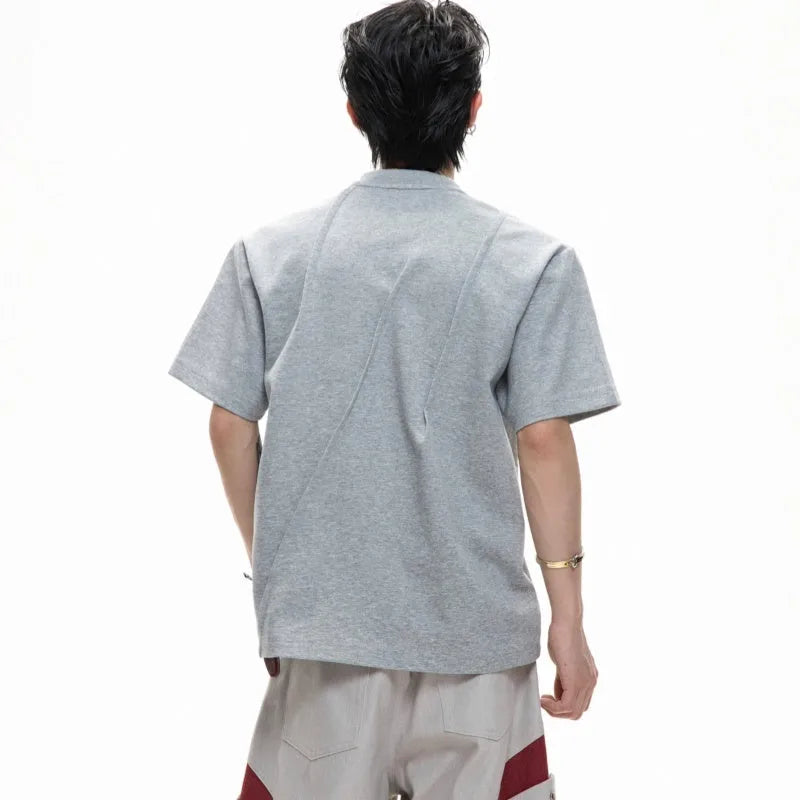 Men's loose grey cotton T-shirt with three-dimensional pleating detail on the front.
