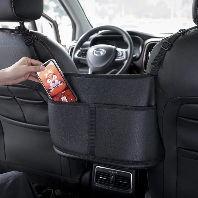 Black leather car seat net pocket storage bag with sports carbon fibre pattern placed between vehicle seats