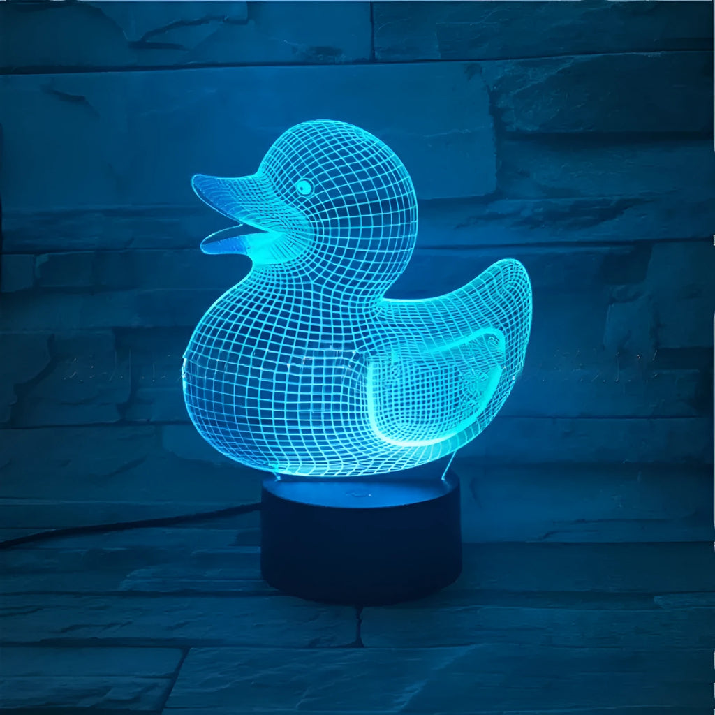 Little yellow duck 3D night light on a table showing its cartoon design and colourful illumination.