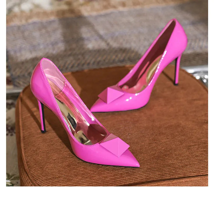 Women's pink patent leather pointed toe stiletto heels with buckle detail and super high heel