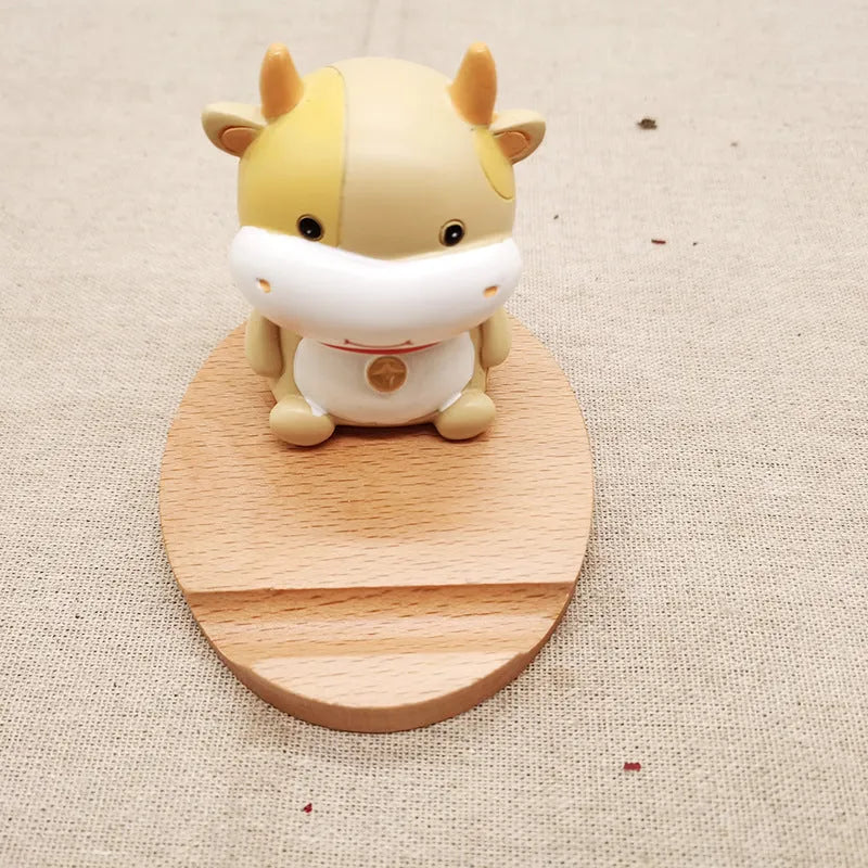 Beech wood mobile phone holder with resin animal decoration and custom lettering on coin back.