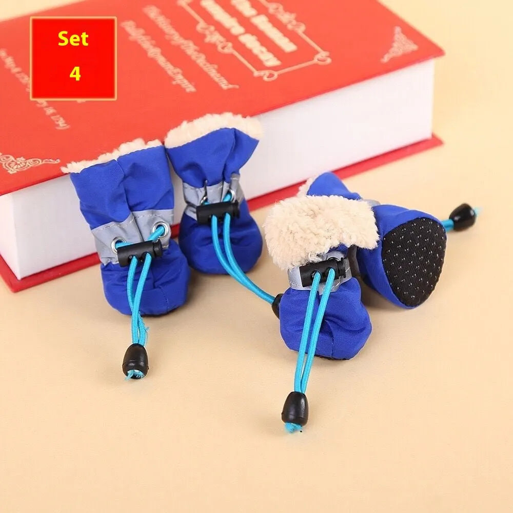 Set of four cloth dog shoes with soft soles in assorted colours on a neutral background
