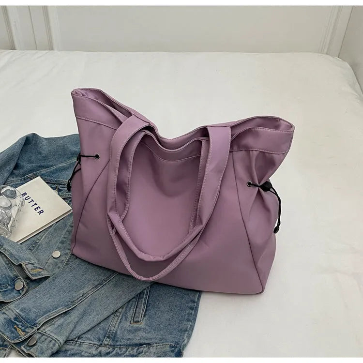 Soft Oxford cloth foldable tote bag shown in one of five colours: black, brown, dark grey, light grey, or purple.