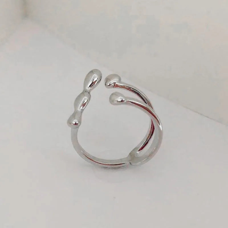 Brass opening ring with circle and sphere design in gold finish on finger