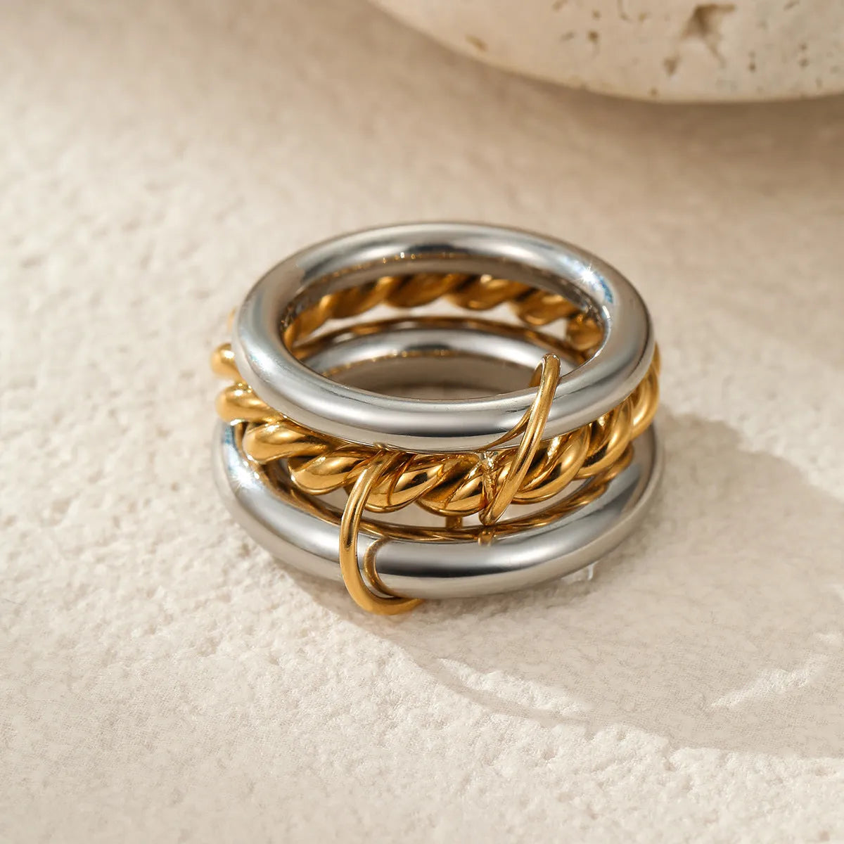 Gold plated stainless steel stacked ring set in three colour variants on a hand.