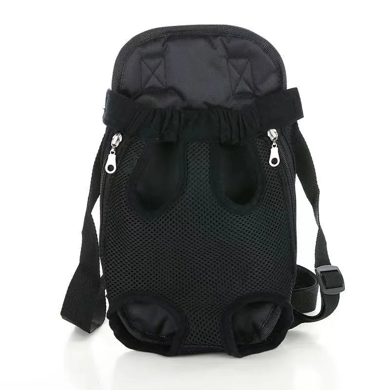 A person wearing a black nylon dog carrier backpack on their chest, containing a small dog looking out.