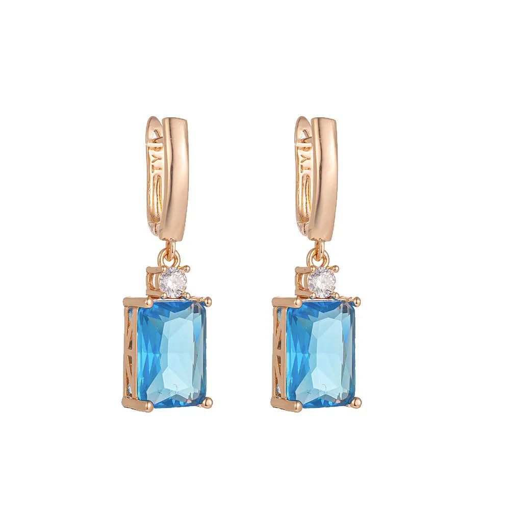 A pair of square-shaped gold and silver electroplated copper earrings showing front view.