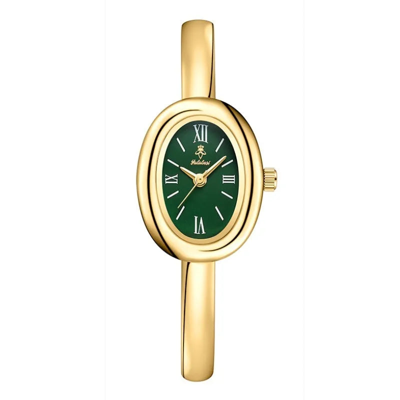 Women's gold and silver oval retro quartz watch with spiral pattern dial on wrist.