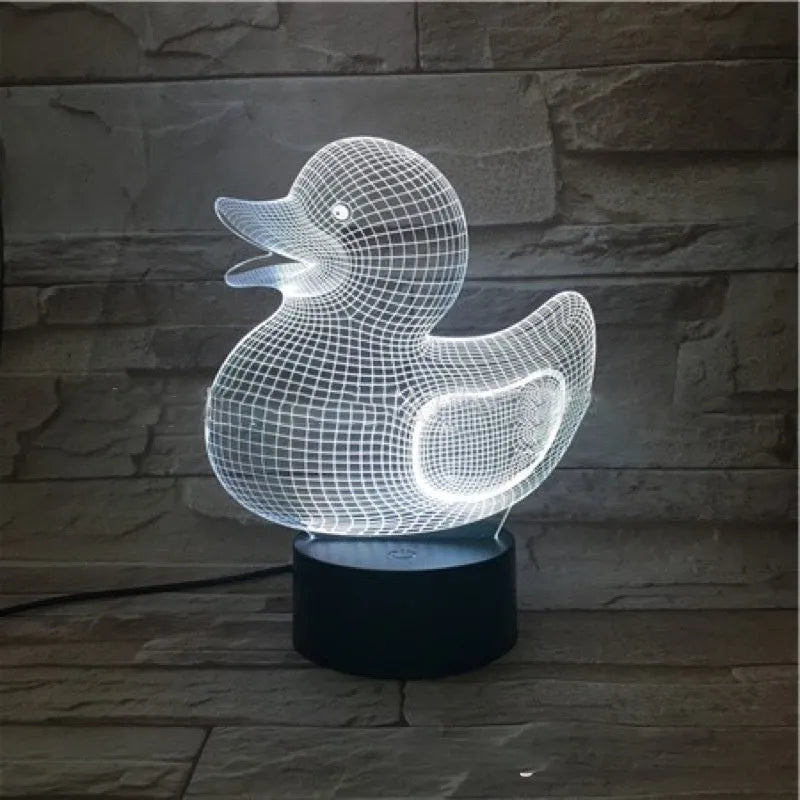 Little yellow duck 3D night light on a table showing its cartoon design and colourful illumination.
