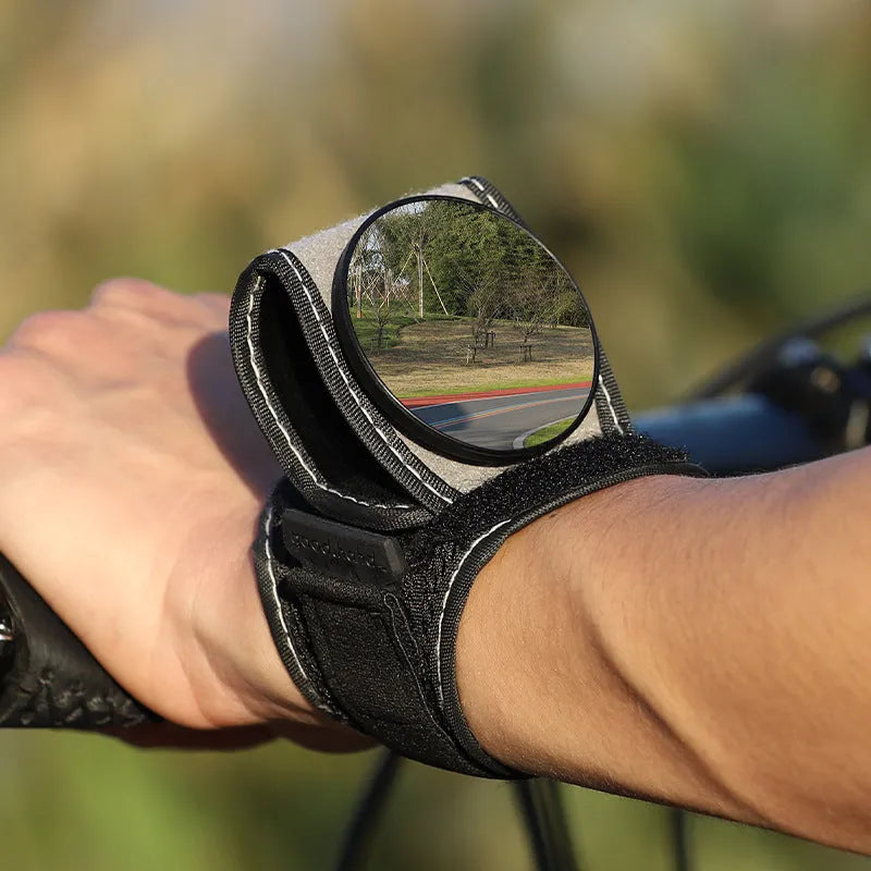 Black wrist-mounted bicycle rear-view mirror showing nylon construction and adjustable viewing angle