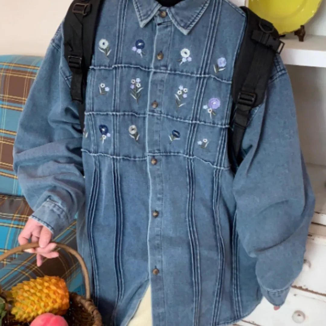 Washed blue denim shirt with small floral pleated detailing and button front closure