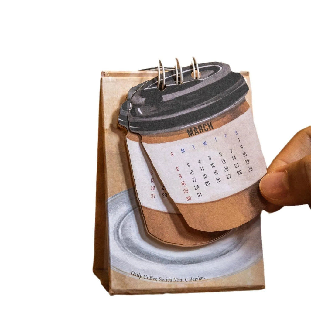 Coffee themed mini desk calendar for 2025 showing four different model designs on a desk.