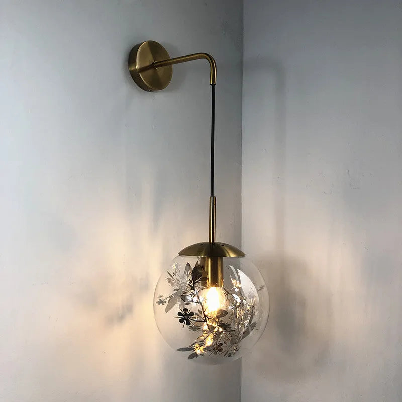 Small modern glass wall lamp in golden flower or silver flower finish for bedside lighting.