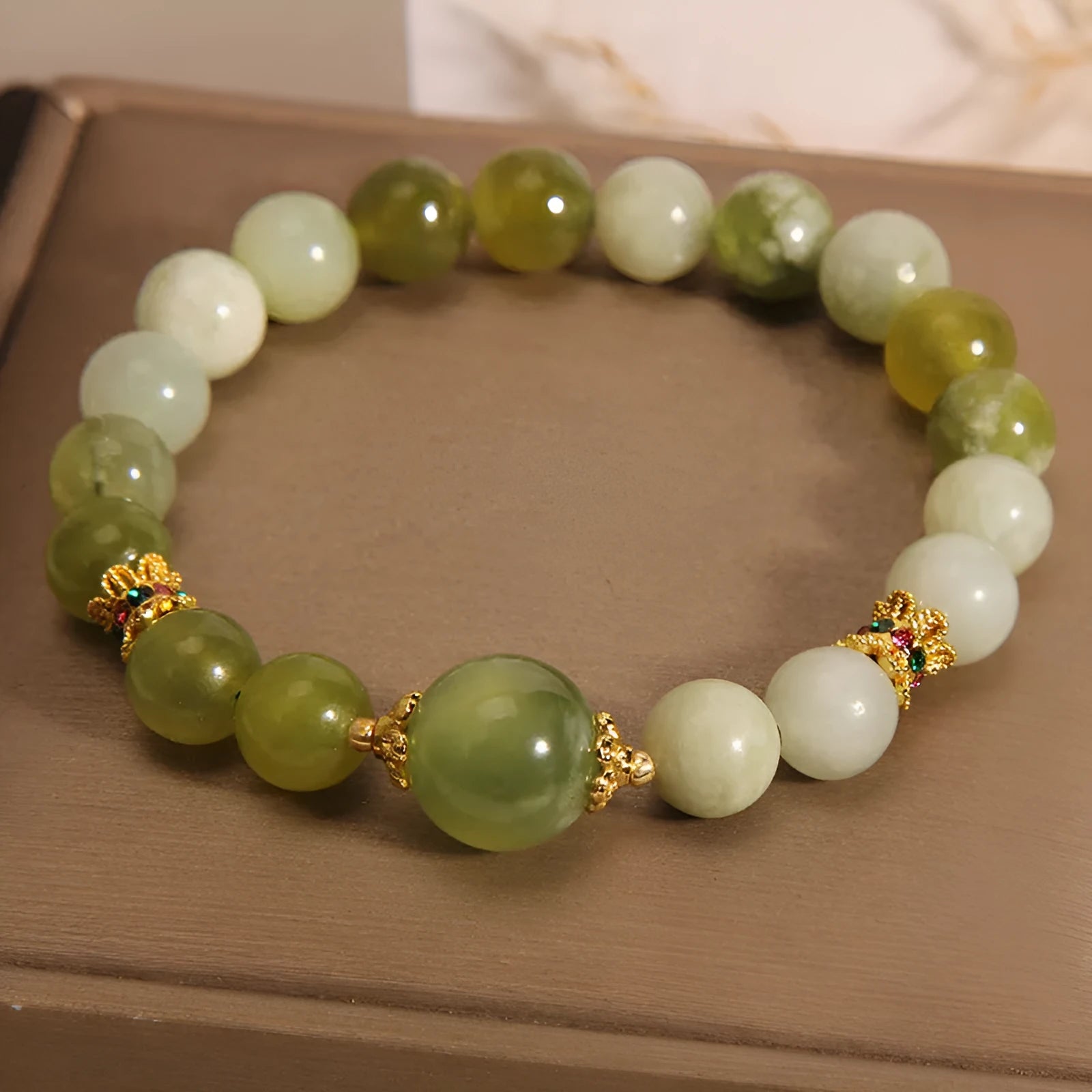 Xiuyan jade green women's bracelet with original design on a wrist.