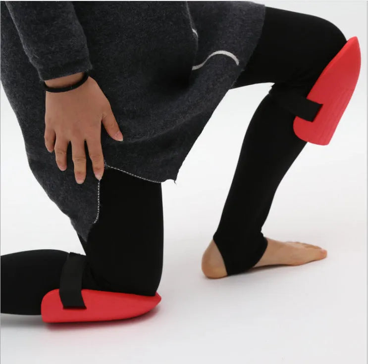 A pair of black EVA foam knee pads showing their rectangular shape and thick profile for knee protection.