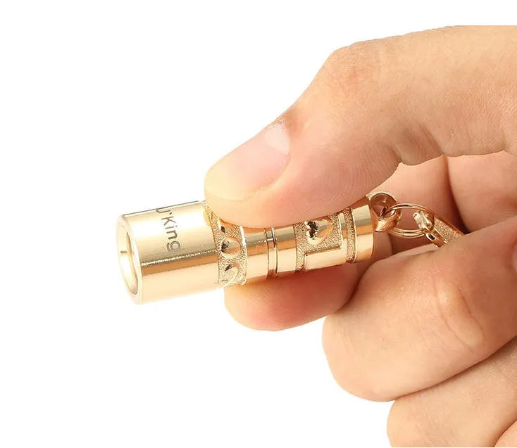Gold zinc alloy waterproof mini LED flashlight attached to a keyring.