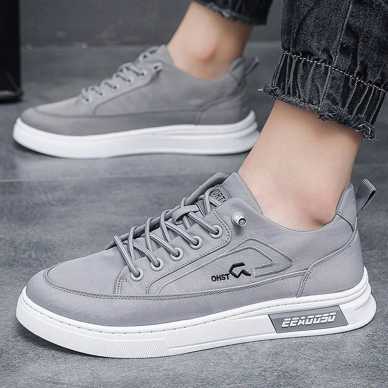 Grey men's low-top canvas casual shoes with a round toe and white rubber sole on a plain background.