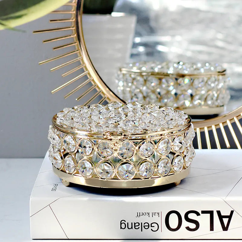 French gold metal jewellery box with a transparent crystal glass lid on a table.