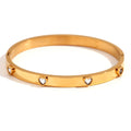 A stainless steel bracelet with a small micro-inlaid peach heart charm, shown in a golden electroplated finish.
