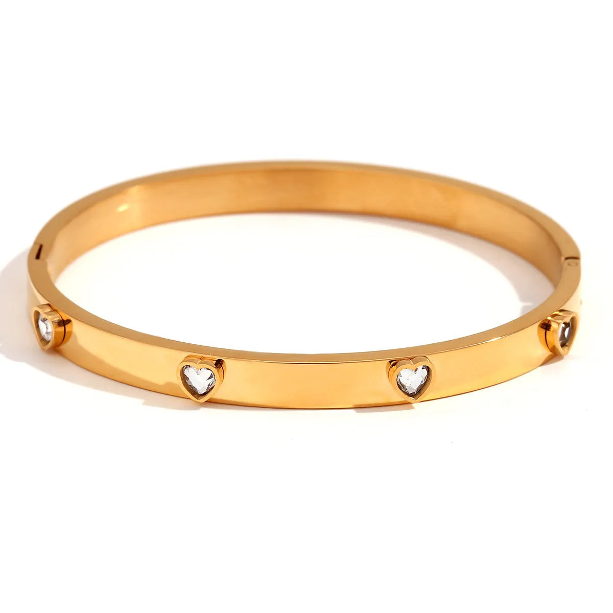 A stainless steel bracelet with a small micro-inlaid peach heart charm, shown in a golden electroplated finish.