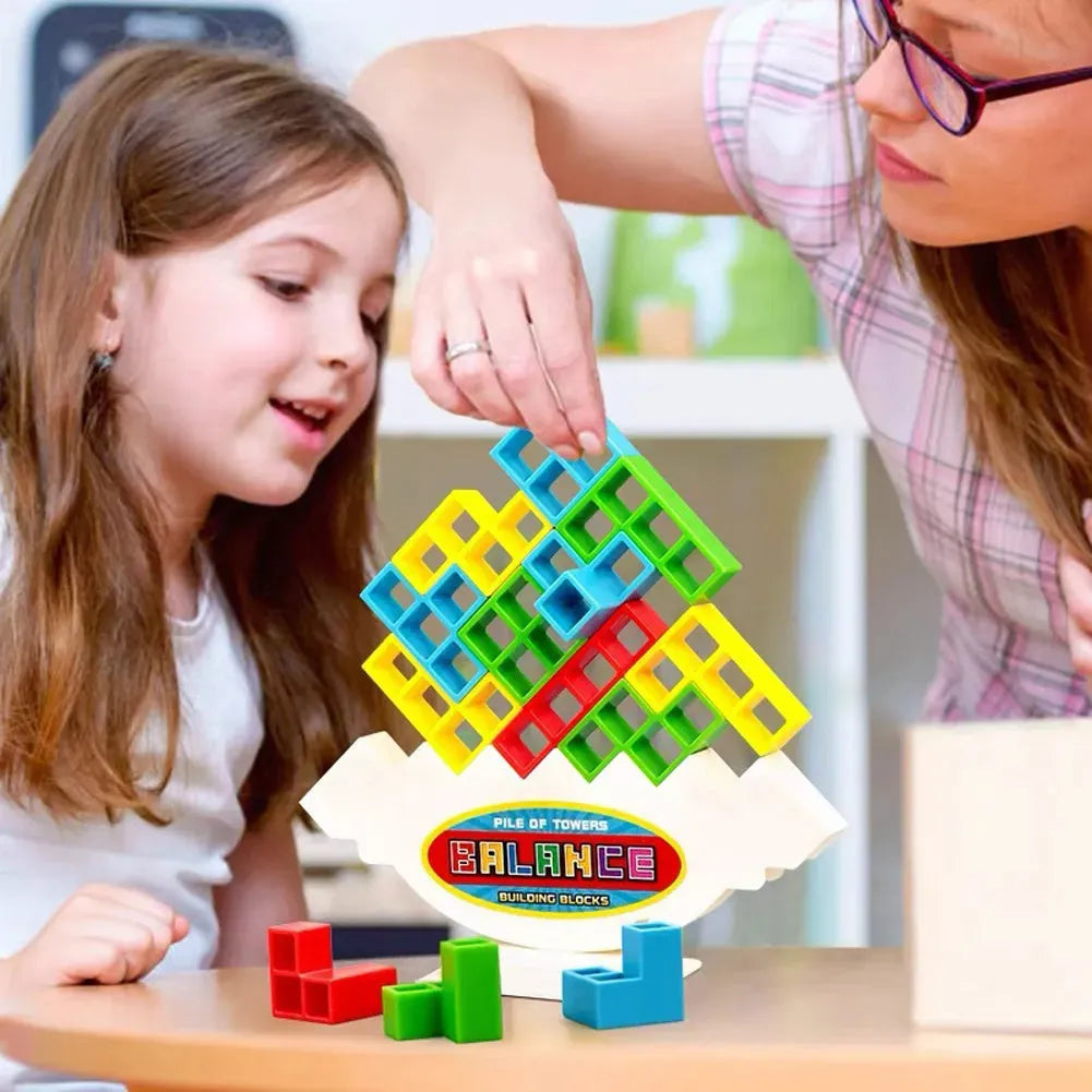 Plastic balance stacking game with 16 colourful building blocks, chassis, and base on a table.