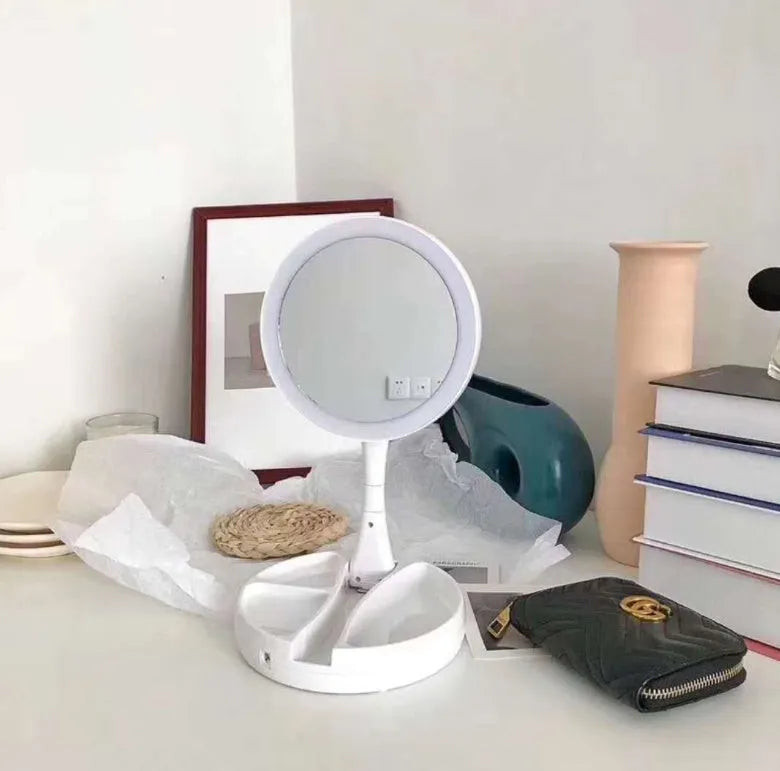 White foldable LED vanity mirror with storage tray and USB cable.