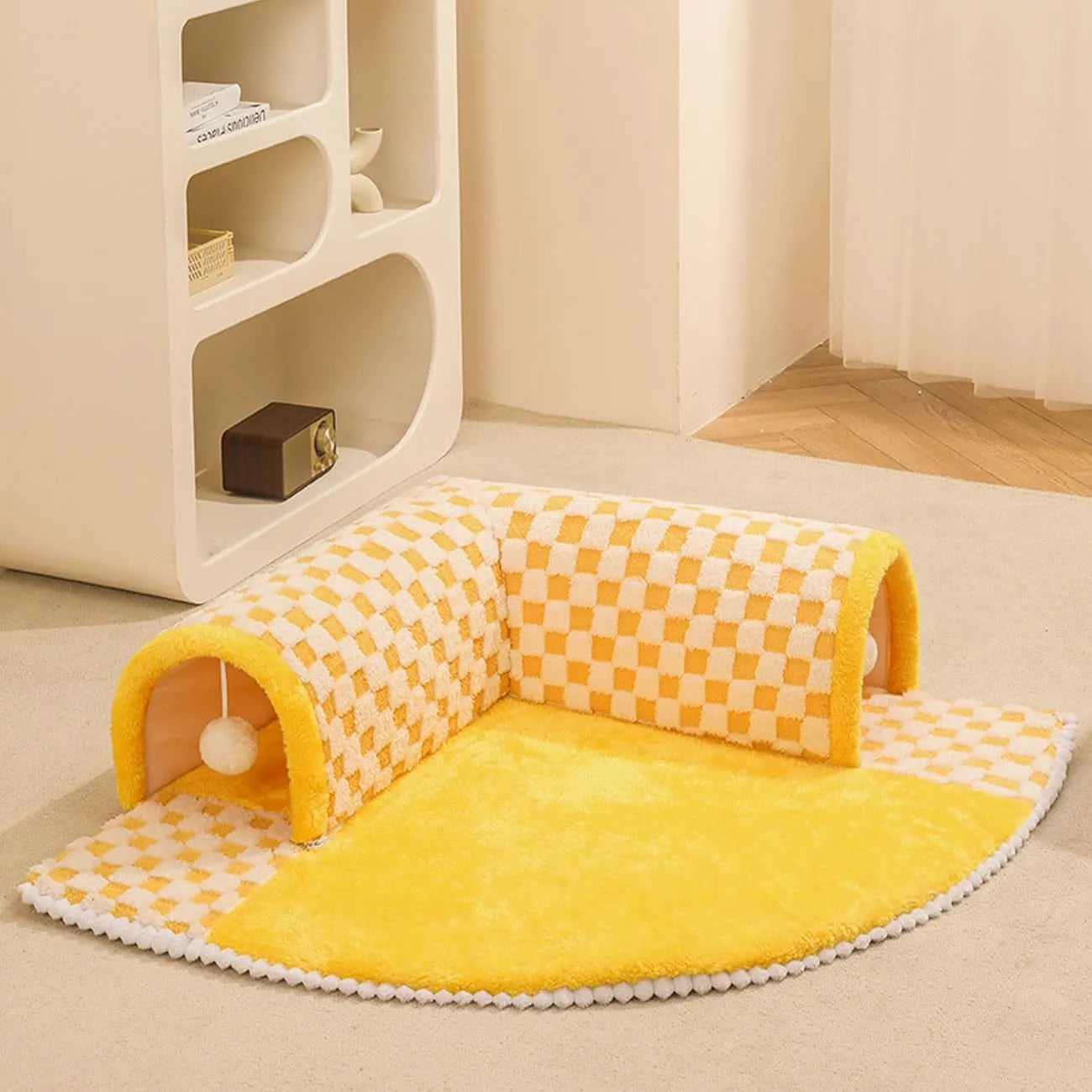 A plush fan-shaped dog and cat bed with an integrated tunnel, shown in a yellow plaid design.