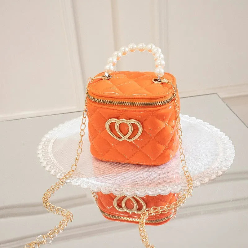 White PVC bucket-shaped cosmetic bag with a red heart pattern, zipper open.