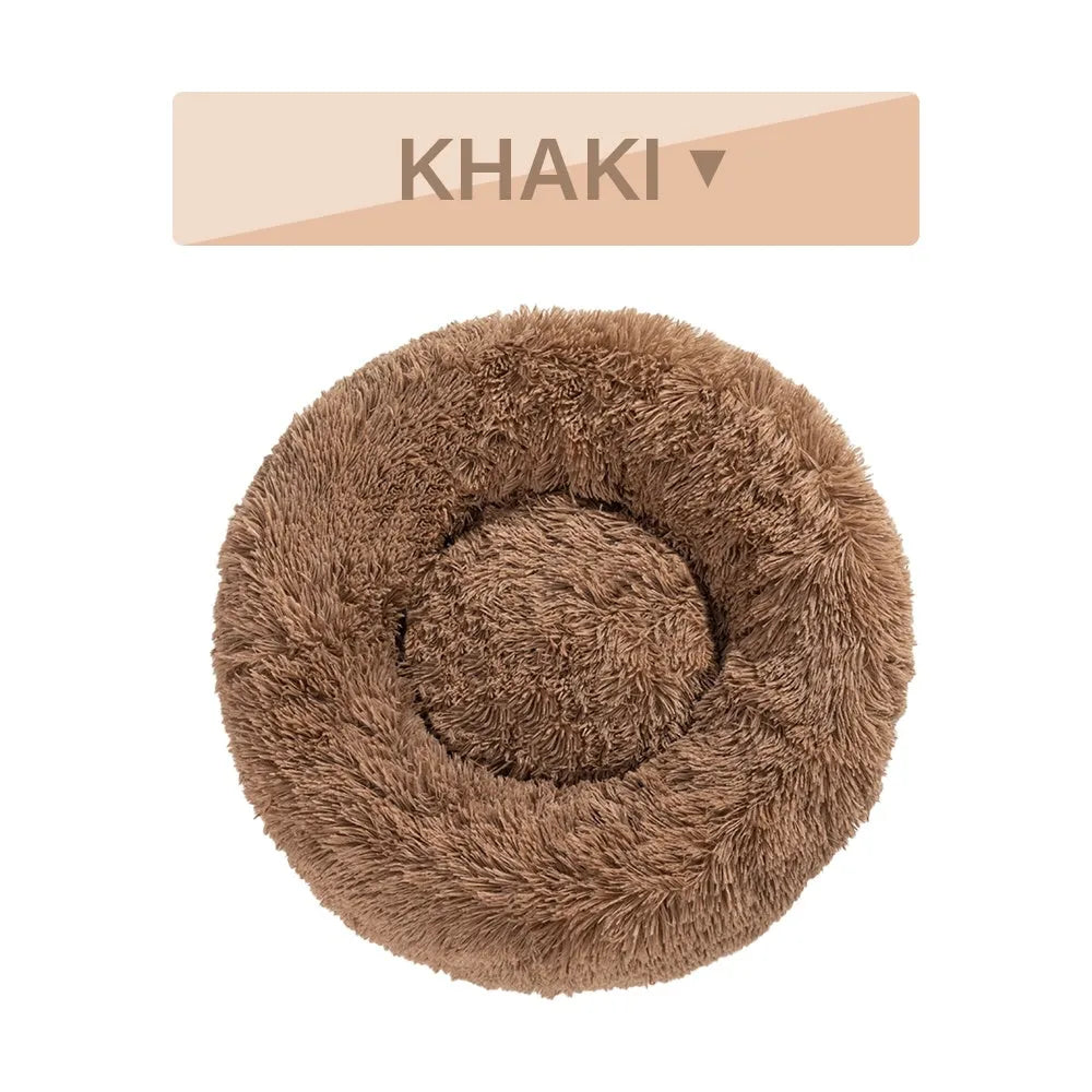 A round donut-shaped dog bed with a raised plush rim, shown in a light grey colour.