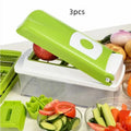 Green manual food chopper with multiple stainless steel accessories on a kitchen counter.