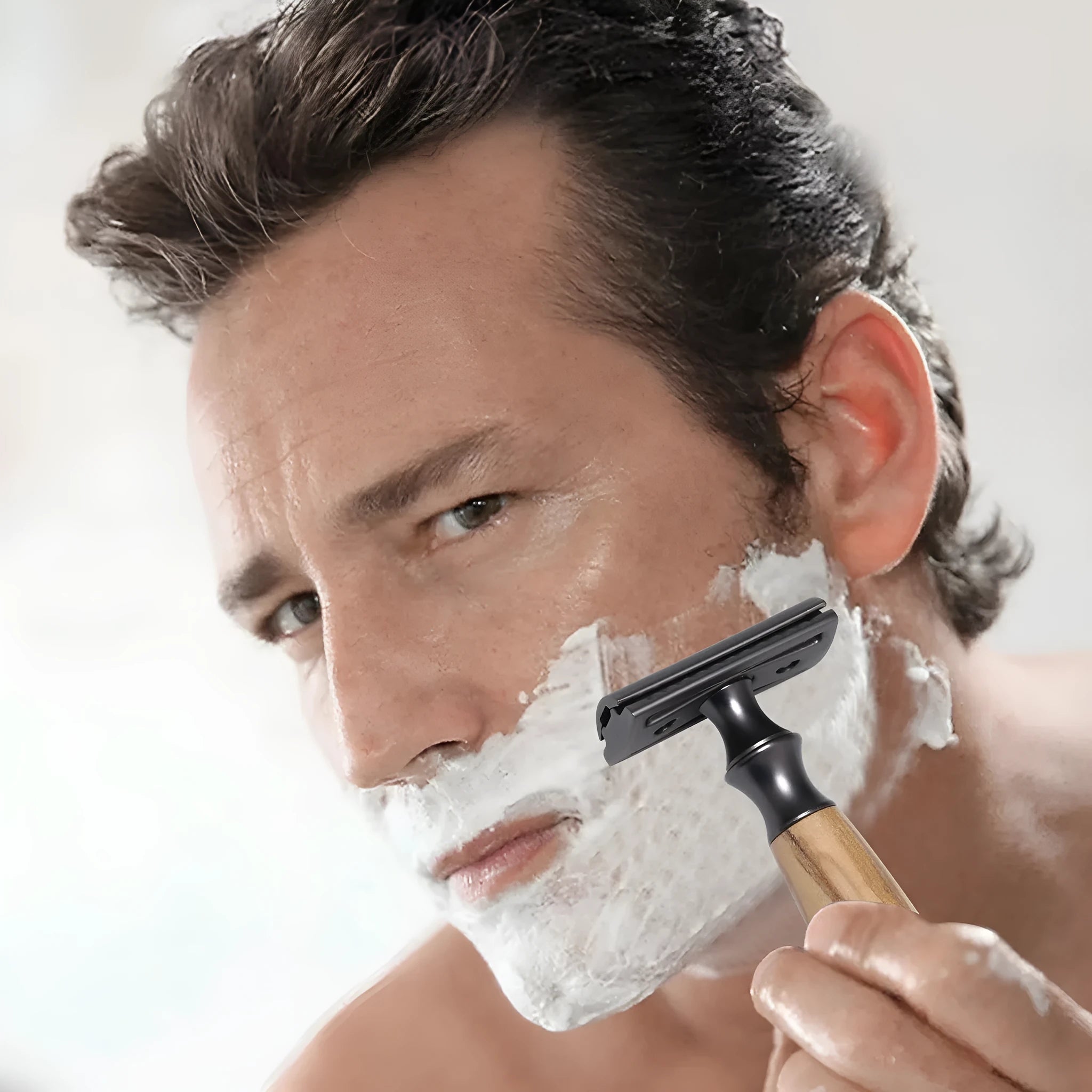 Men's copper safety razor with olive wood handle, blade holder stand, and shaving accessories