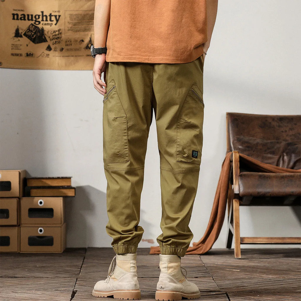 Men's cotton harem pants in khaki with tapered legs and ankle band.