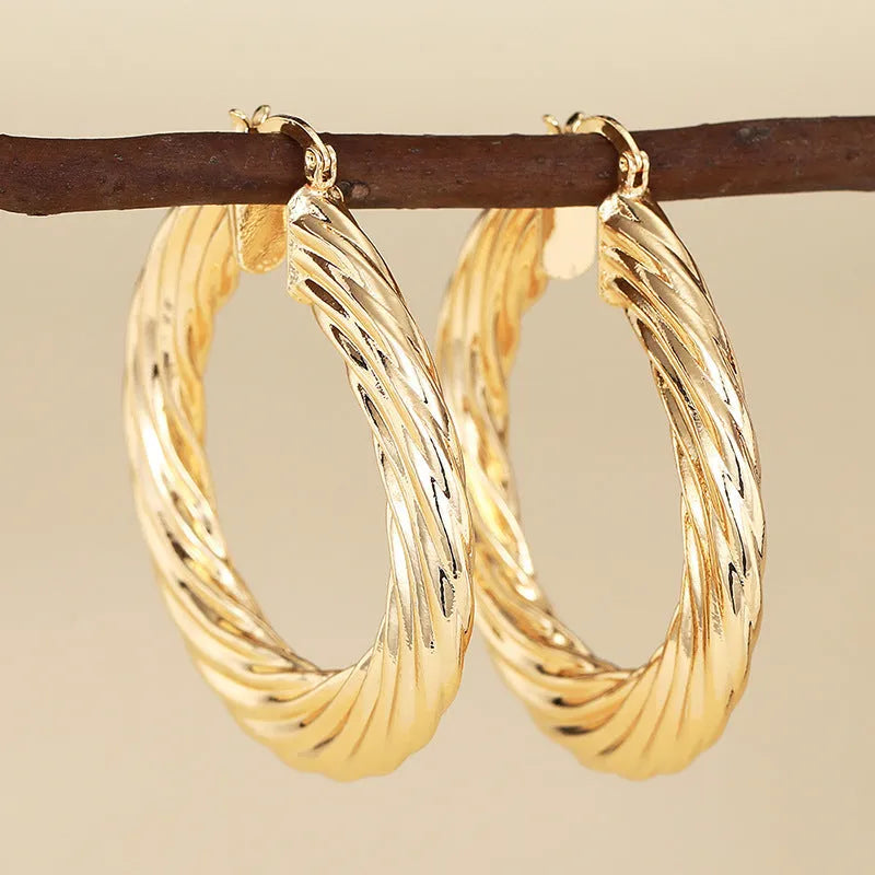 Geometric drop-shaped ear clips with ring and line design in metallic finish
