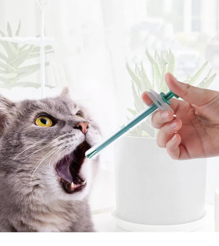 Two white pet pill shooter dispensers with soft silicone tips and push rods for administering tablets to cats and dogs.