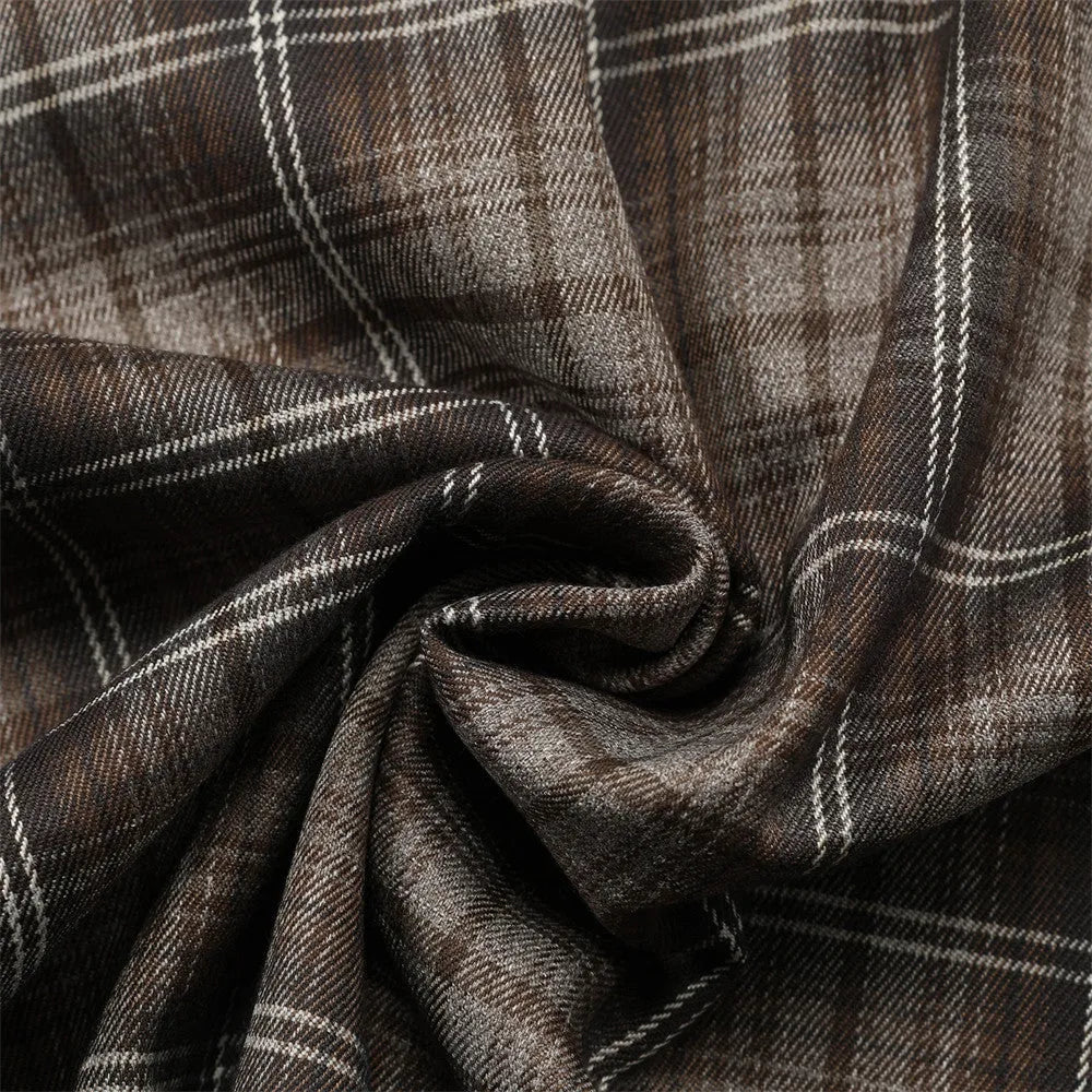 Man wearing a brown plaid short sleeve shirt with embroidery on the lapel