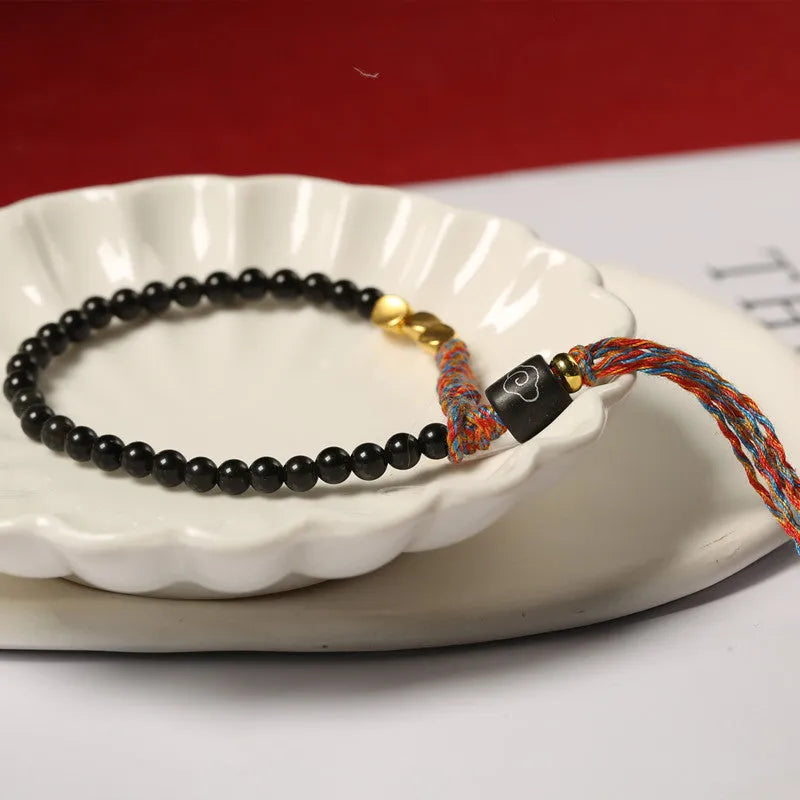 Hand-woven obsidian carrying strap bracelet showing 4mm width and woven texture detail