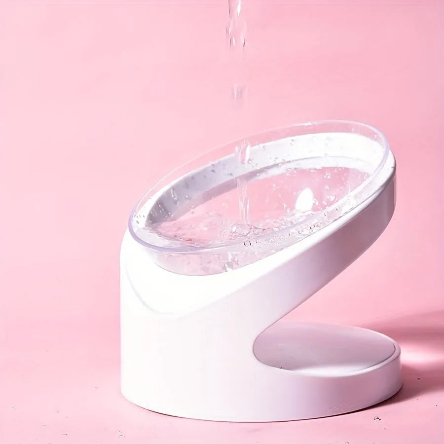 White clear plastic tilted cat food bowl on a flat surface.