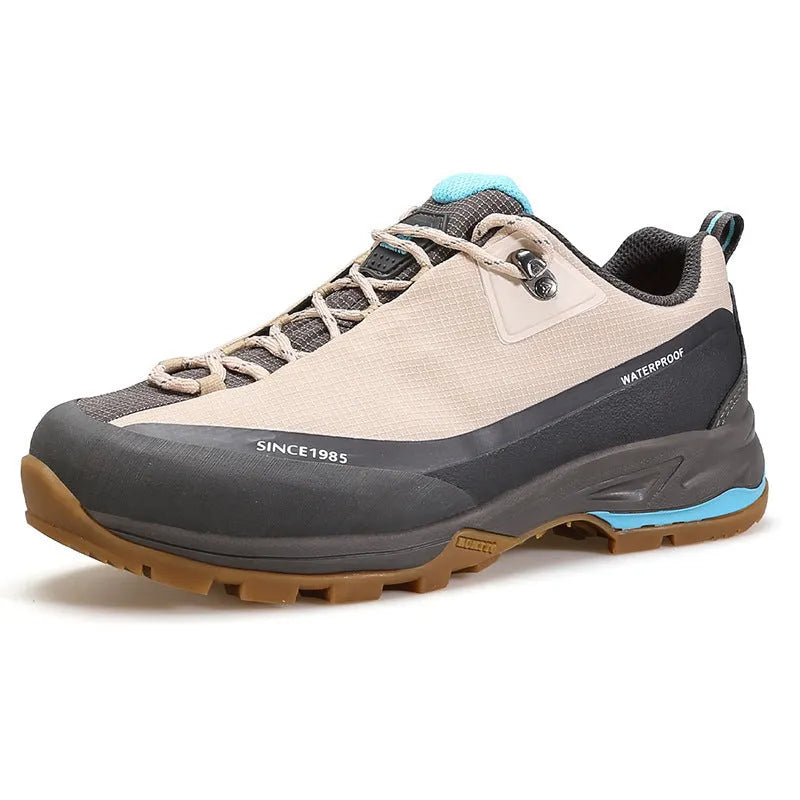 Men's low-top hiking boots in black with leather mesh upper and rubber outsole on a rocky path.