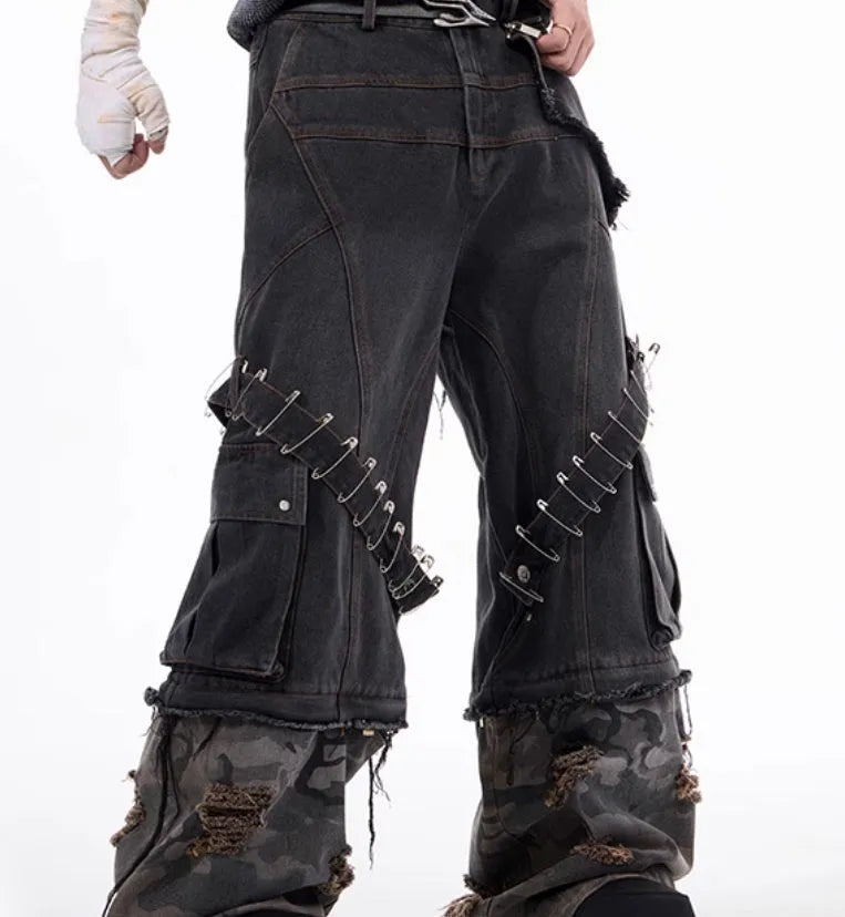 Men's grey camouflage pattern jeans with spliced panels and decorative pin details.