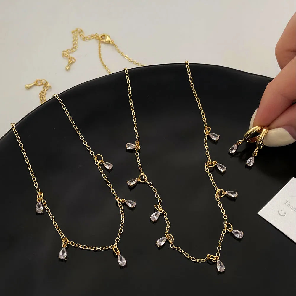 Zircon jewellery set with geometric pendant necklace, matching earrings, and anklet in silver-tone chain