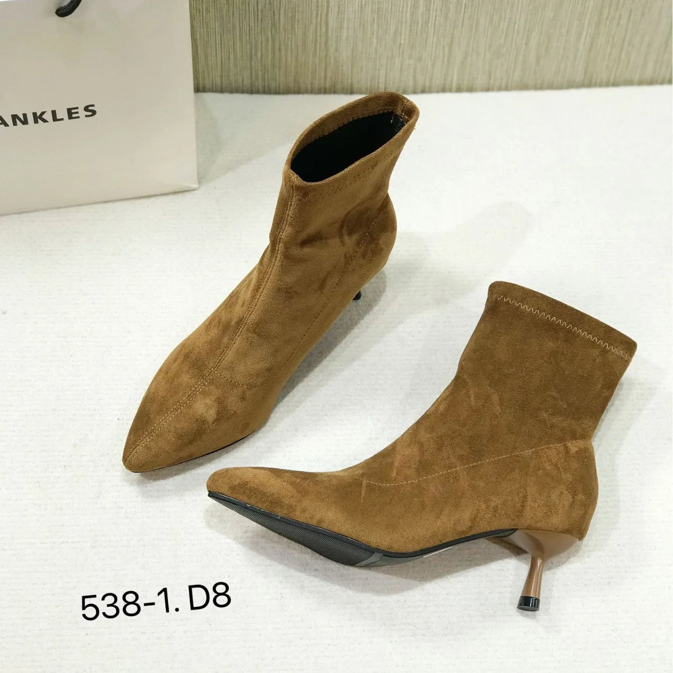 Women's black pointed toe ankle boots with stiletto heel on a plain background
