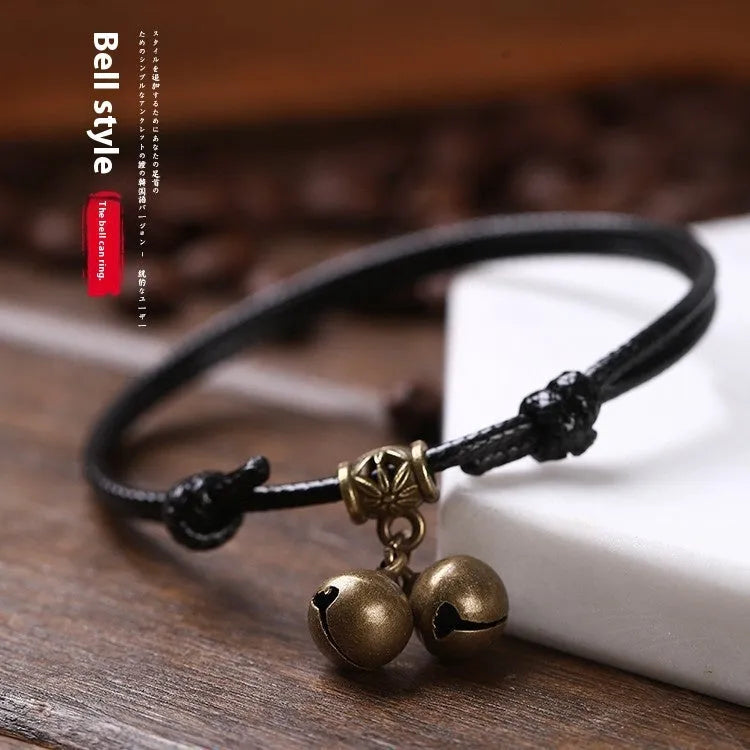 Adjustable black nylon rope dog collar for small dogs featuring a brass bell, shown alongside red and coffee colour options.