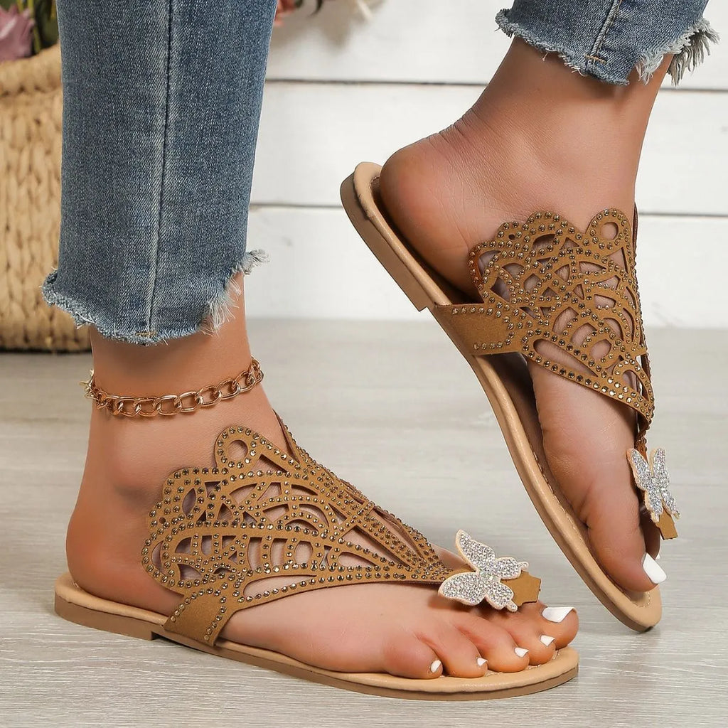 Women's black slip-on sandals with rhinestone details on hollow upper and flat rubber sole