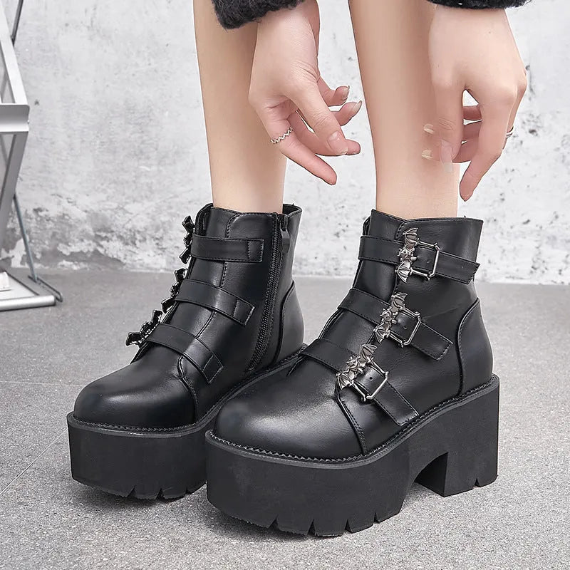 Black women's gothic punk Martin boots with bat buckle and side zipper on a thick heel.